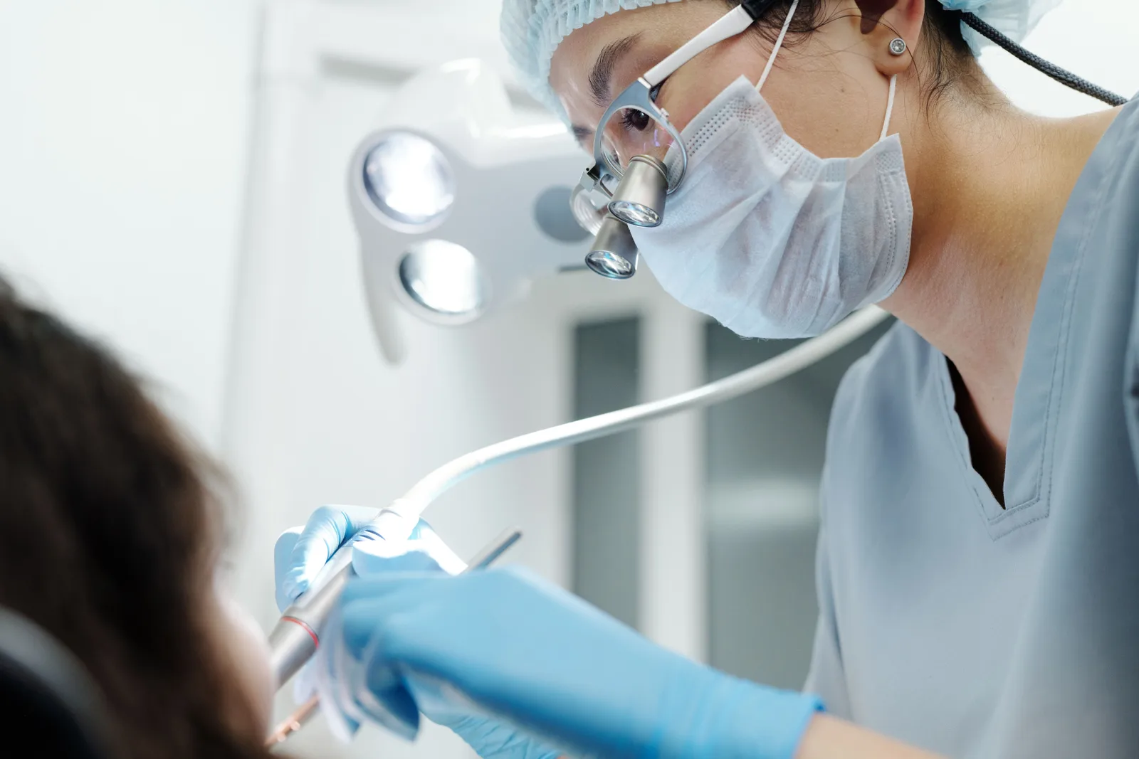 Dentista usando lupas de aumento durante um procedimento