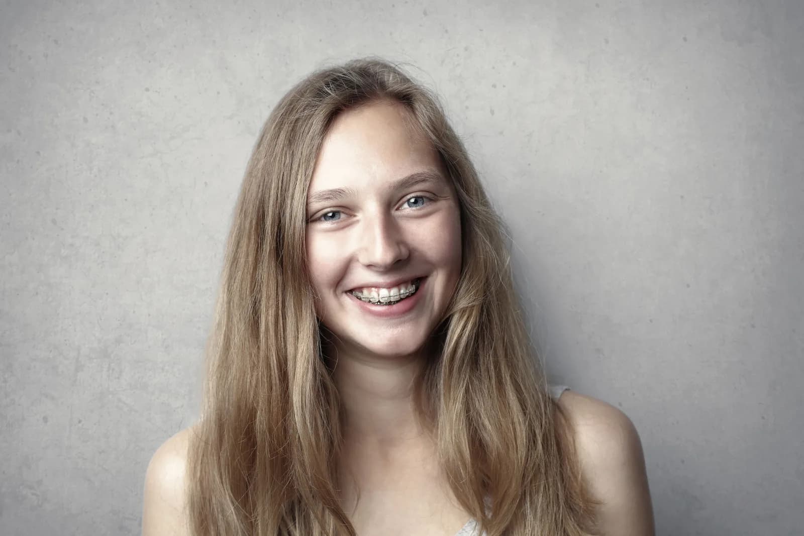Retrato de jovem sorrindo com aparelho ortodôntico