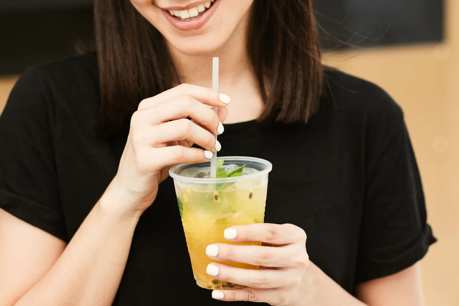 Mulher tomando uma bebida gelada com canudo