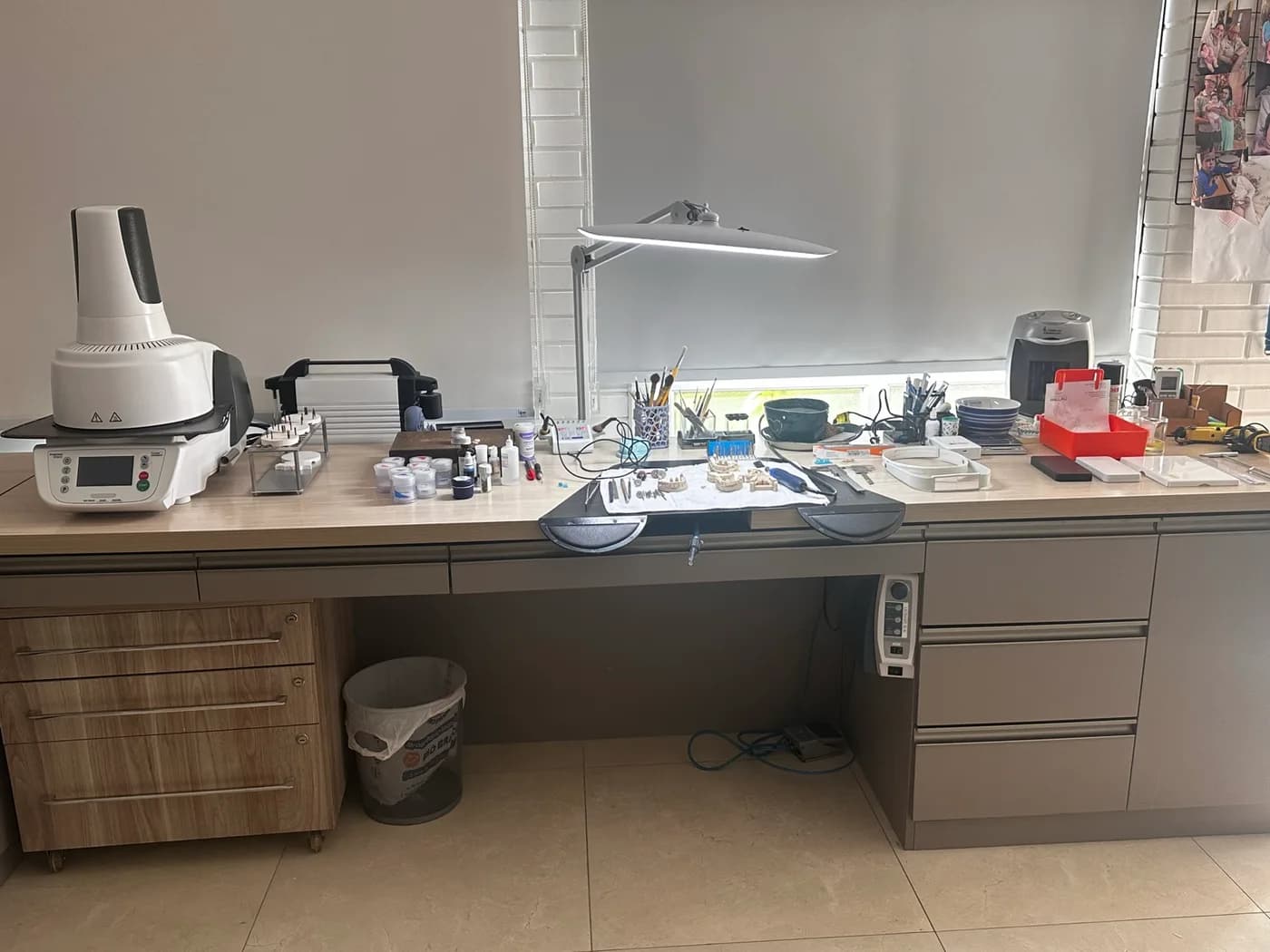Bancada de trabalho do laboratório com luminária articulada e instrumentos sobre a superfície