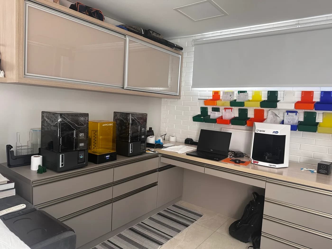 Bancada do laboratório com equipamentos e monitor, e escala de cores na parede
